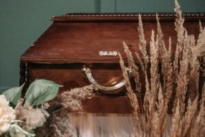 A beautifully crafted wooden coffin adorned with dried flowers, evoking a serene and respectful atmosphere.
